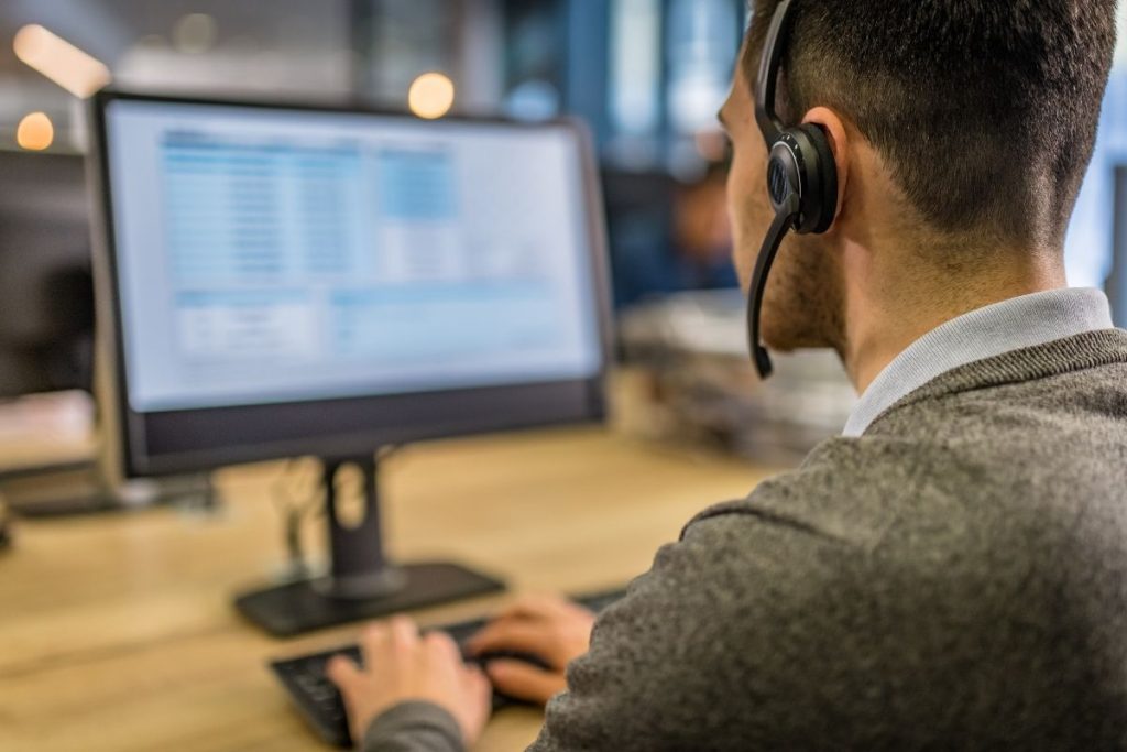 Hombre con auriculares trabajando frente a su computador